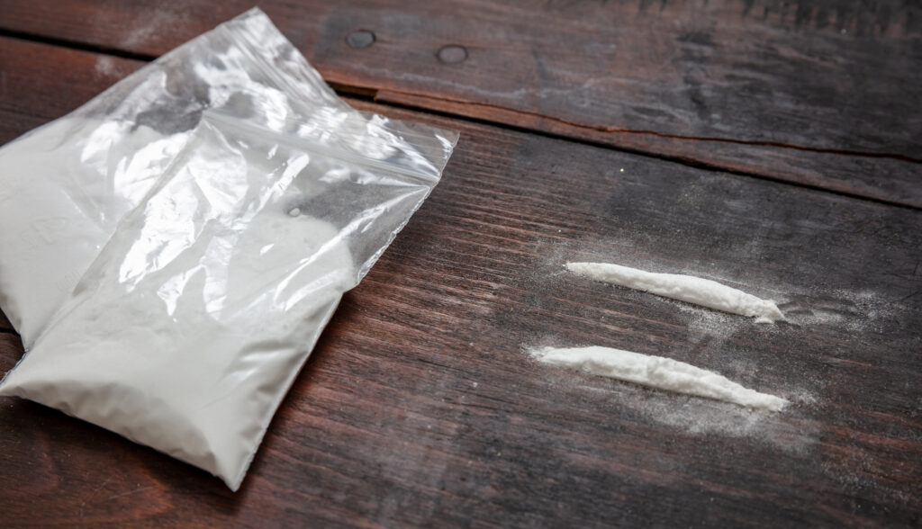 cocaine-plastic-packets-and-two-lines-on-wooden