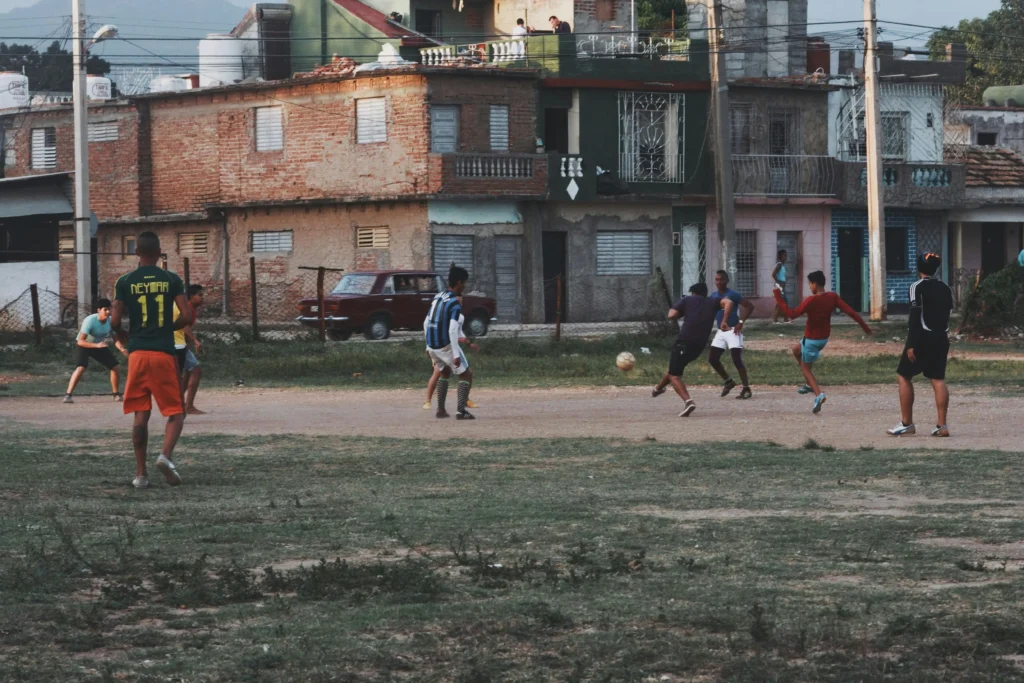 Young boys playing football in a artesal pitch